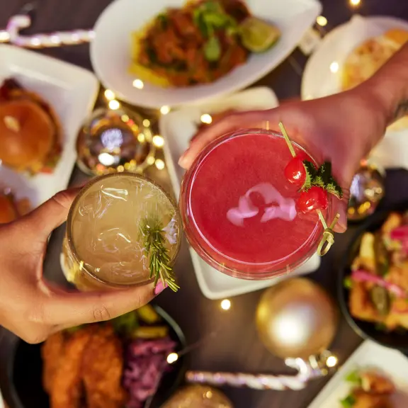Two people cheersing with cocktails at SOUND London