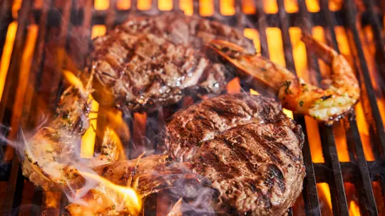 Prawns and Steak on a grill at SOUND London